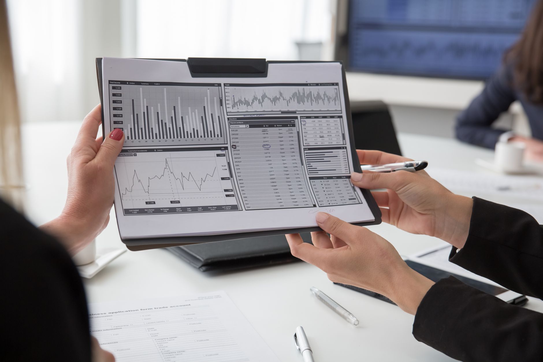 Two colleagues reviewing printed data charts together during a business meeting.