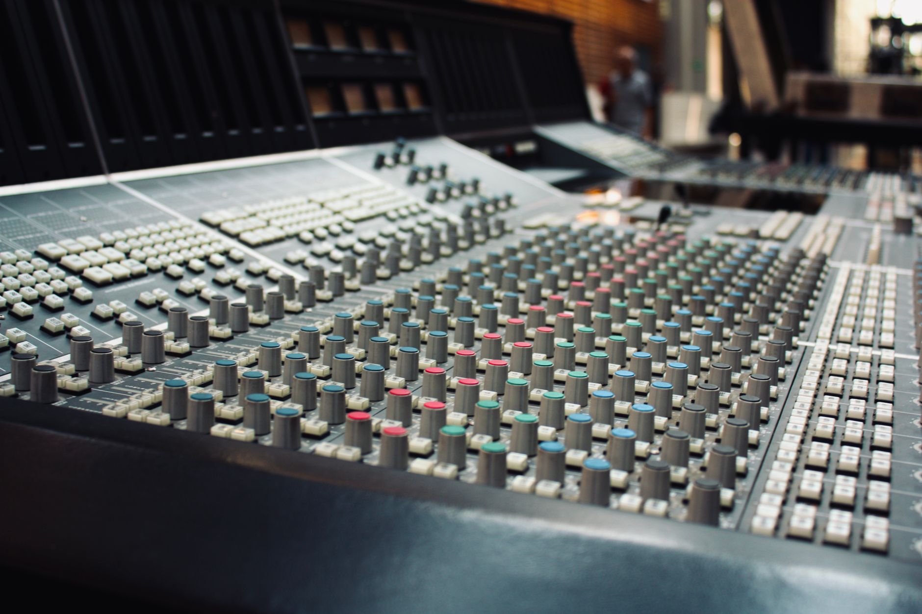 Close-up of a professional audio mixing console in a recording studio.
